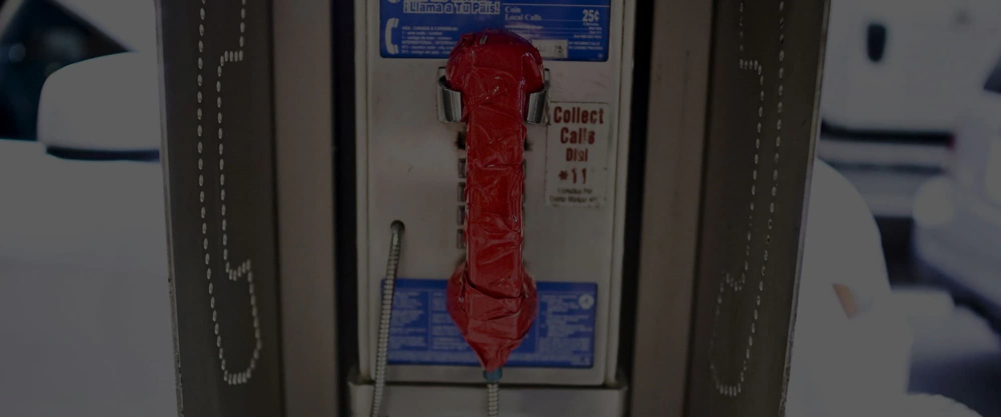 A payphone with a red handset